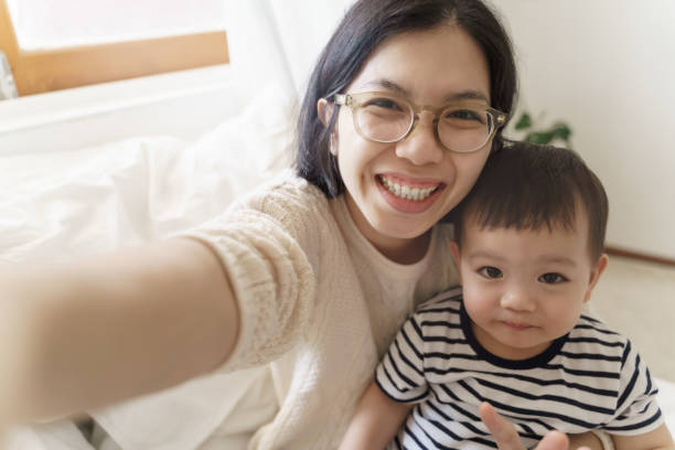 istock Chinese mother and her son using smartphone taking selfie photos 1402012748