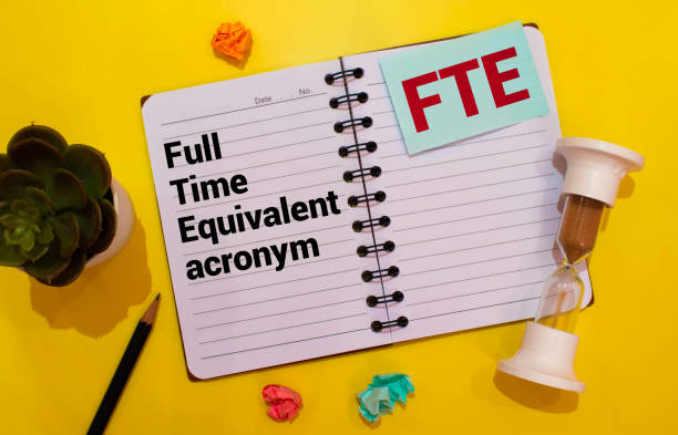 istock Text FTE Full Time Equivalent writing on notebook with hand holding pencil 1402015595