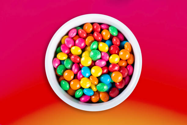 Sweet colored confetti in white bowl top view