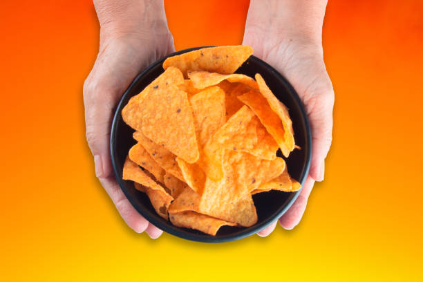 istock Hand holding bowl with crunchy cheese chips 1402021468