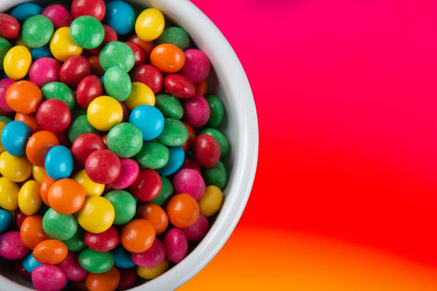 istock Sweet colored confetti in white bowl top view. 1402021569