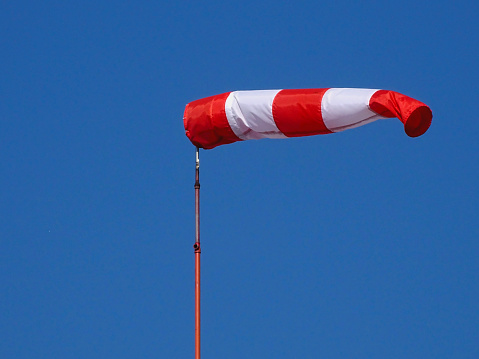 A depiction in close-up and low-angle view of a windsock floating in the wind. Photo shot in early June 2022, in Dusseldorf, Germany.