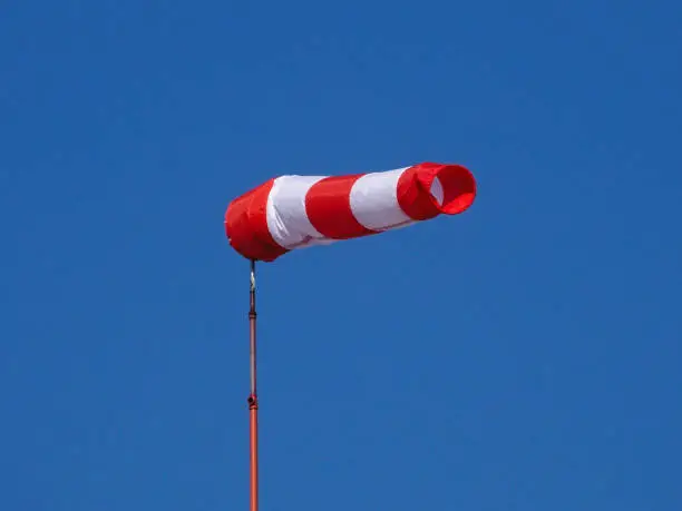 A depiction in close-up and low-angle view of a windsock floating in the wind. Photo shot in early June 2022, in Dusseldorf, Germany.