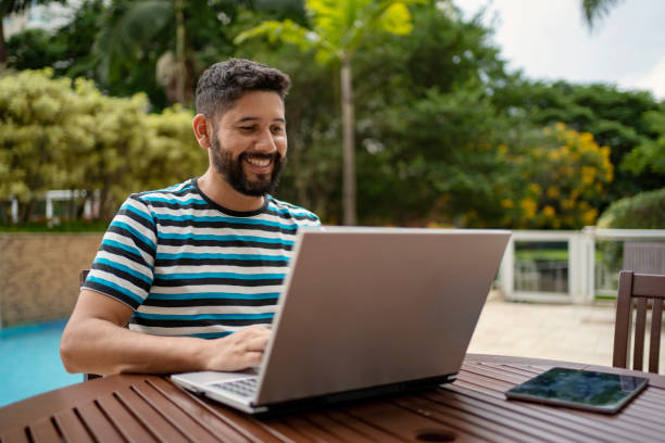 istock Man working on laptop near pool at a hotel 1402026171