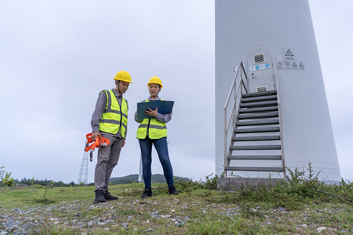 Two Asian engineers discuss data in the wind turbine group