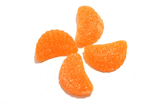 Candy Orange Slices - sugar covered orange gummy candy shaped like orange slices with white background - arranged