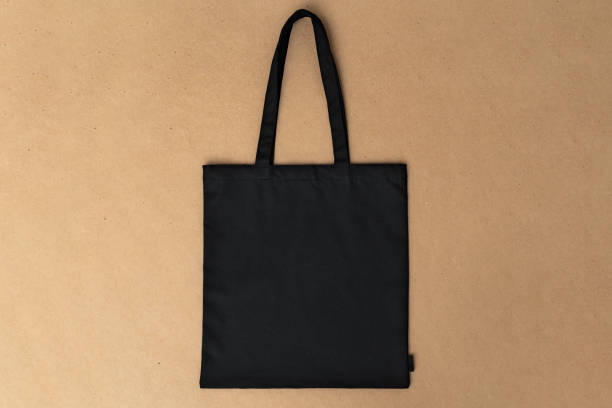 istock Black textile shopping bag on beige background flat lay 1402039987
