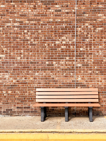 Bench in front of a brick wall
