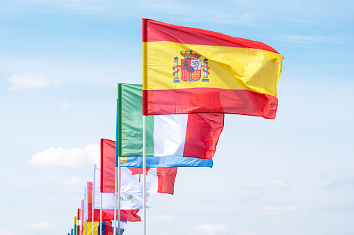 Flags of different countries flutters in the wind against