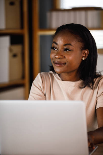 istock Joyful young businesswoman sitting at her desk, contemplating while using laptop 1402045745