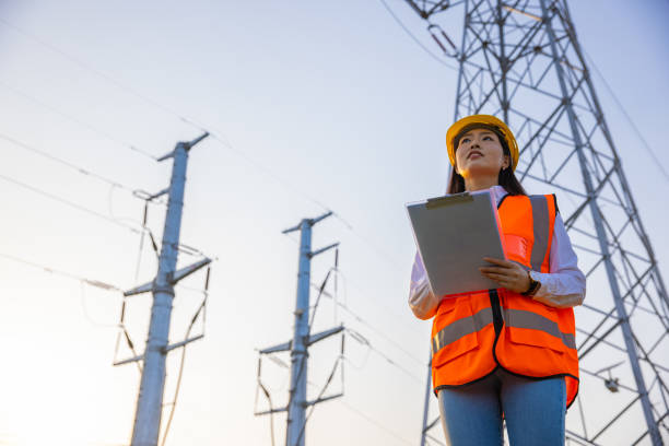 Women electrical engineer working Women electrical engineer while working near to high voltage tower asian female engineer stock pictures, royalty-free photos & images