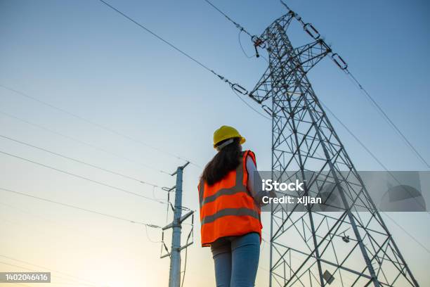 Female Engineer Working Near Highvoltage Tower Stock Photo - Download Image Now - Electricity, Power Line, Electricity Pylon