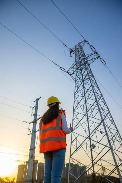 istock Female engineer working near high-voltage tower 1402046418