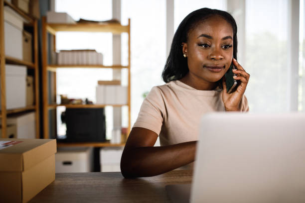istock Smiling businesswoman talking on the phone and using laptop 1402046436