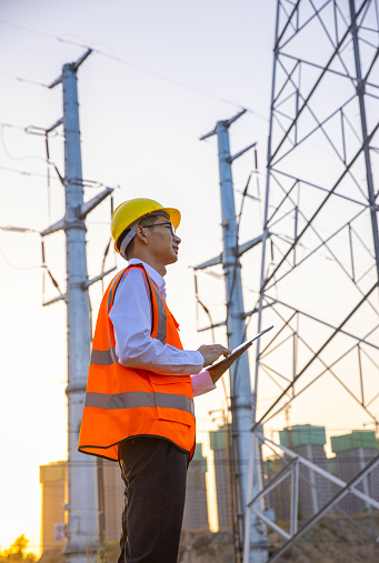 Engineer man looking and checking high voltage tower