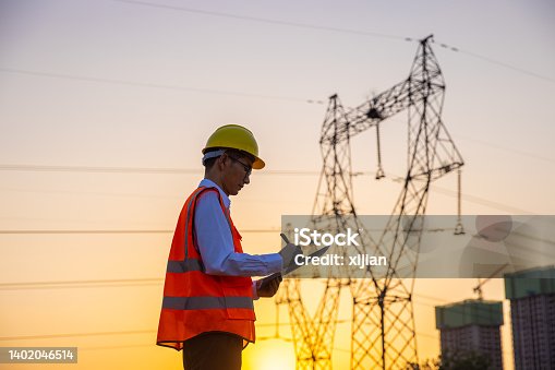 istock Engineer working by high voltage tower 1402046514