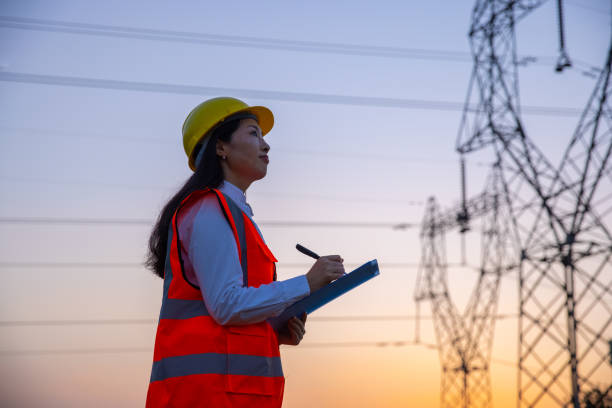 istock Female engineer working near high-voltage tower 1402046629