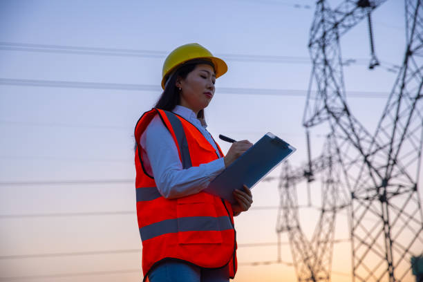 istock Female engineer working near high-voltage tower 1402046641