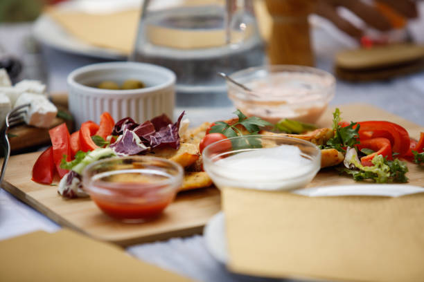 istock Delicious board with meat, salad and dipping sauces served on a dining table 1402048093
