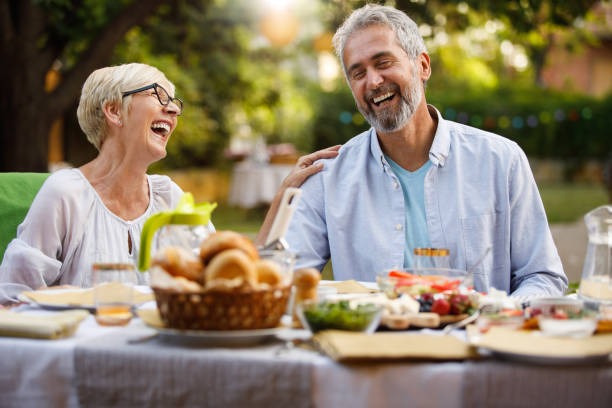 istock Two friends having bonding moments and laughing together during dinner party 1402048111