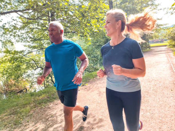 istock Mature Mixed Race Couple Jogging Outdoors On A Fresh Summer Morning 1402048988