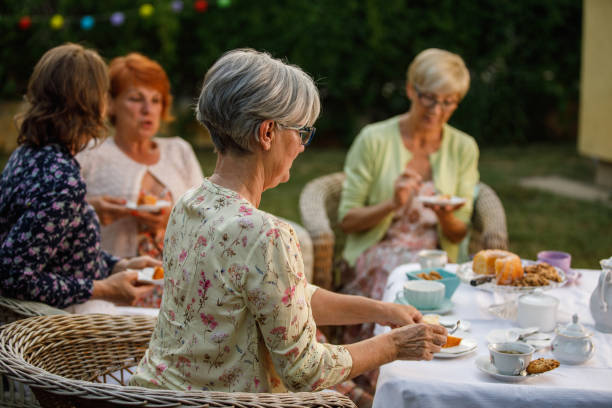 istock Elderly girlfriends enjoying cake and tea in the back yard 1402049060