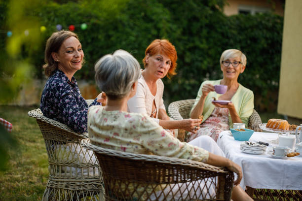 istock Group of four elderly girlfriends chatting and bonding during afternoon tea 1402049081