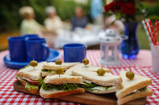 Close up shot of delicious club sandwiches served with green olives as a snack for Fourth of July celebration with friends.