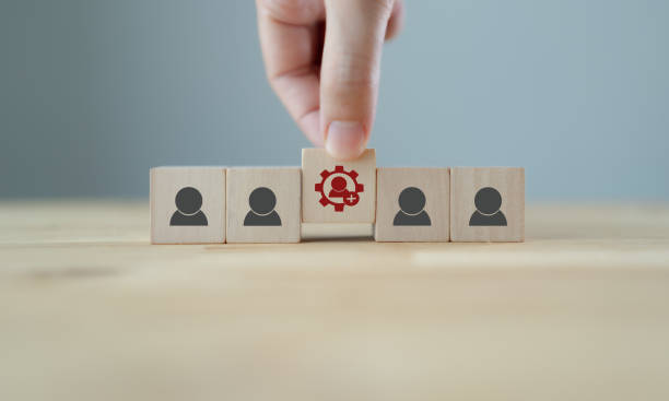 istock New skills concept to develop performance of human resources for business growth and digital transformation. Man holds wood cube with new skills icon symbol on many staff icon symbol; copy space. 1402052780