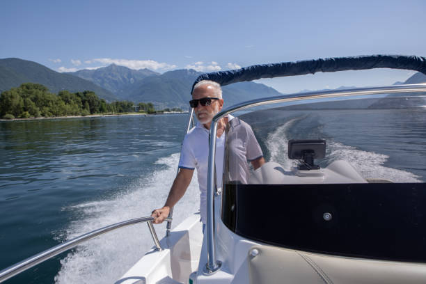 istock Senior man driving a speed boat on a lake in summer 1402053775