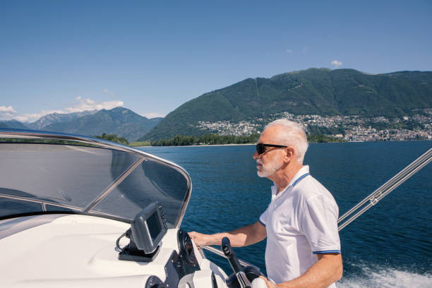 istock Senior man driving a speed boat on a lake in summer 1402053997