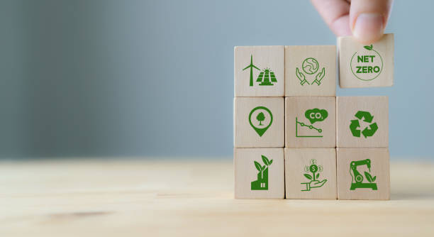 istock Net zero and carbon neutral concept. Net zero greenhouse gas emissions target. Climate neutral long term strategy.  Hand puts wooden cubes with green net zero icon and save world icon on blue background. 1402054728
