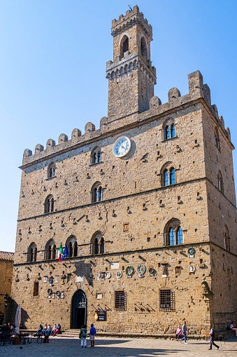 The Palazzo dei Priori is a 13th century building located in the old town of Volterra, that today houses part of the municipal offices, as well as temporary exhibitions. People stroll in the homonymous square.