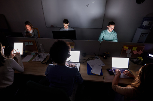 Group of entrepreneurs working on computers late in the office.
