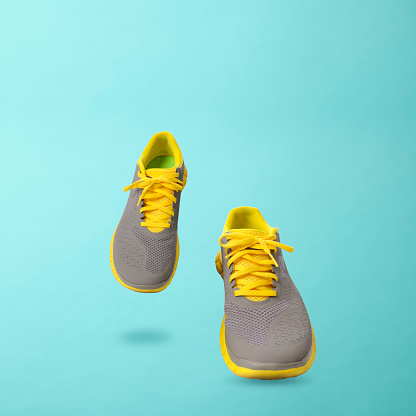 Walking sneakers against light blue background with copy space.