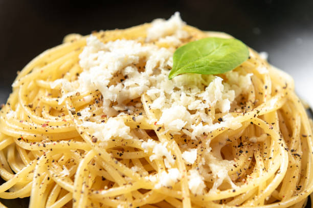 istock Spaghetti with cheese and peppers on a dark plate 1402058095