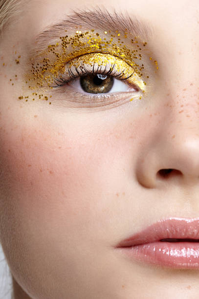 primo piano macro scatto di viso femminile umano con trucco di bellezza giallo occhi fumosi. - glitter make up eyelash human face foto e immagini stock