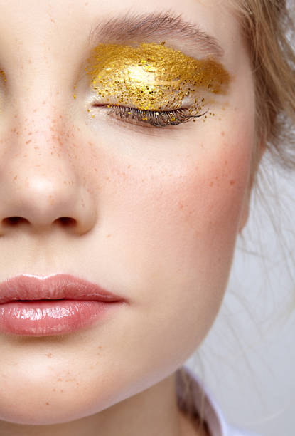primo piano macro scatto di viso femminile umano con trucco di bellezza giallo occhi fumosi. - glitter make up eyelash human face foto e immagini stock