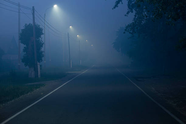 led 가로등으로 비추는 짙은 안개가있는 어두운 저녁에 도시의 도로 - nobody horror spooky road 뉴스 사진 이미지