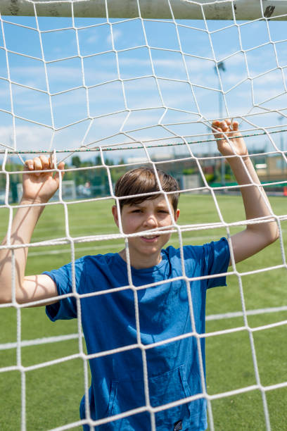 istock Boy holding football goal net while looking at camera 1402064477