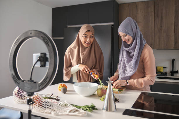 istock Two muslim food vloggers explaning how to prepare a salad at kitchen. 1402065737