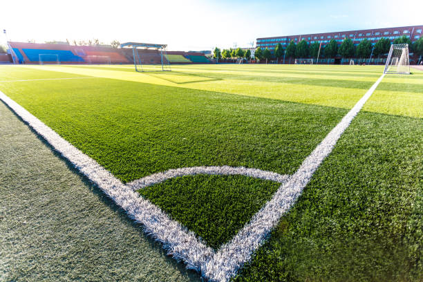 istock Football green grass field with corner white lines 1402066128