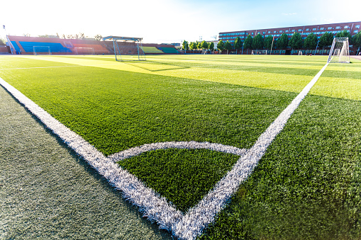 Closeup of a corner kick area on a green artificial turf surface of a soccer field