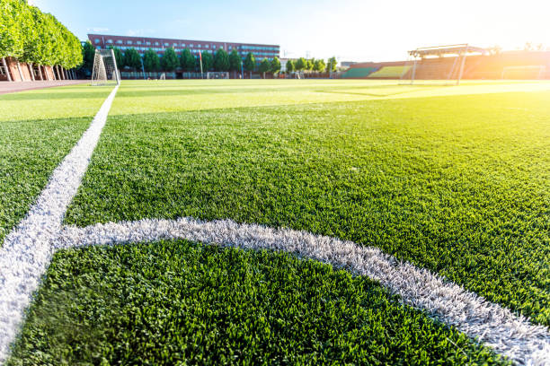 istock Football green grass field with corner white lines 1402067118