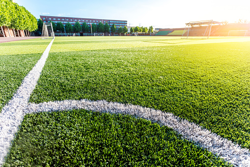 Closeup of a corner kick area on a green artificial turf surface of a soccer field