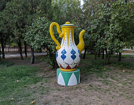 Large teapot as a detail from the carousel stands on the street