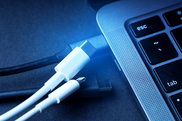 istock External SSD, phone charger, USB type c cables near the modern laptop close up. Interaction with modern office equipment. 1402068633