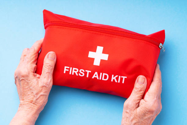 istock Old wrinkled hands holding first aid kit. 1402069584