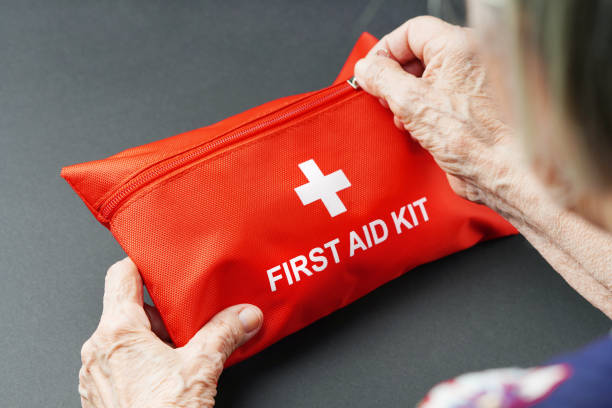 istock Old wrinkled hands opening first aid kit. 1402069691