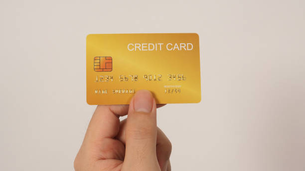istock Hand is holding gold credit card isolated on white background.